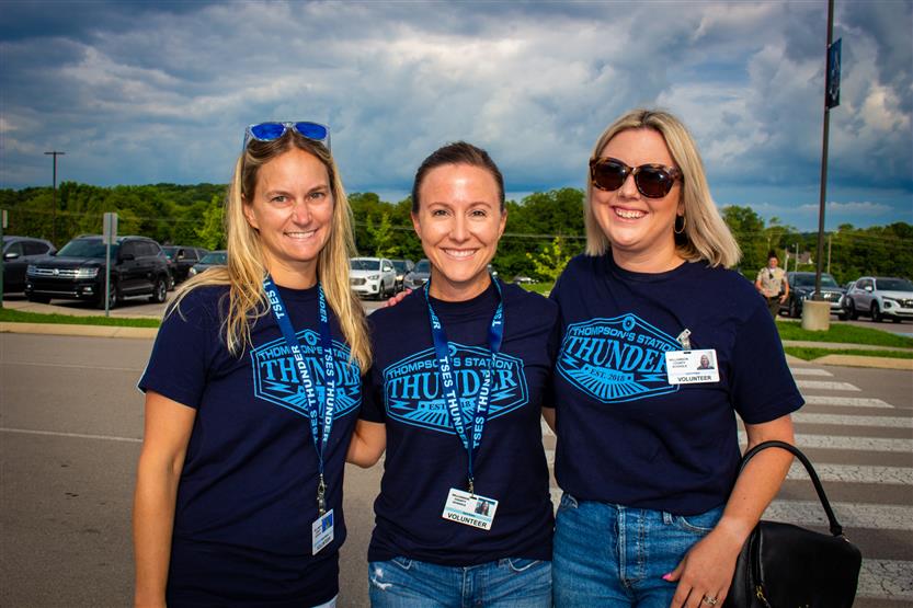 Three volunteers smile